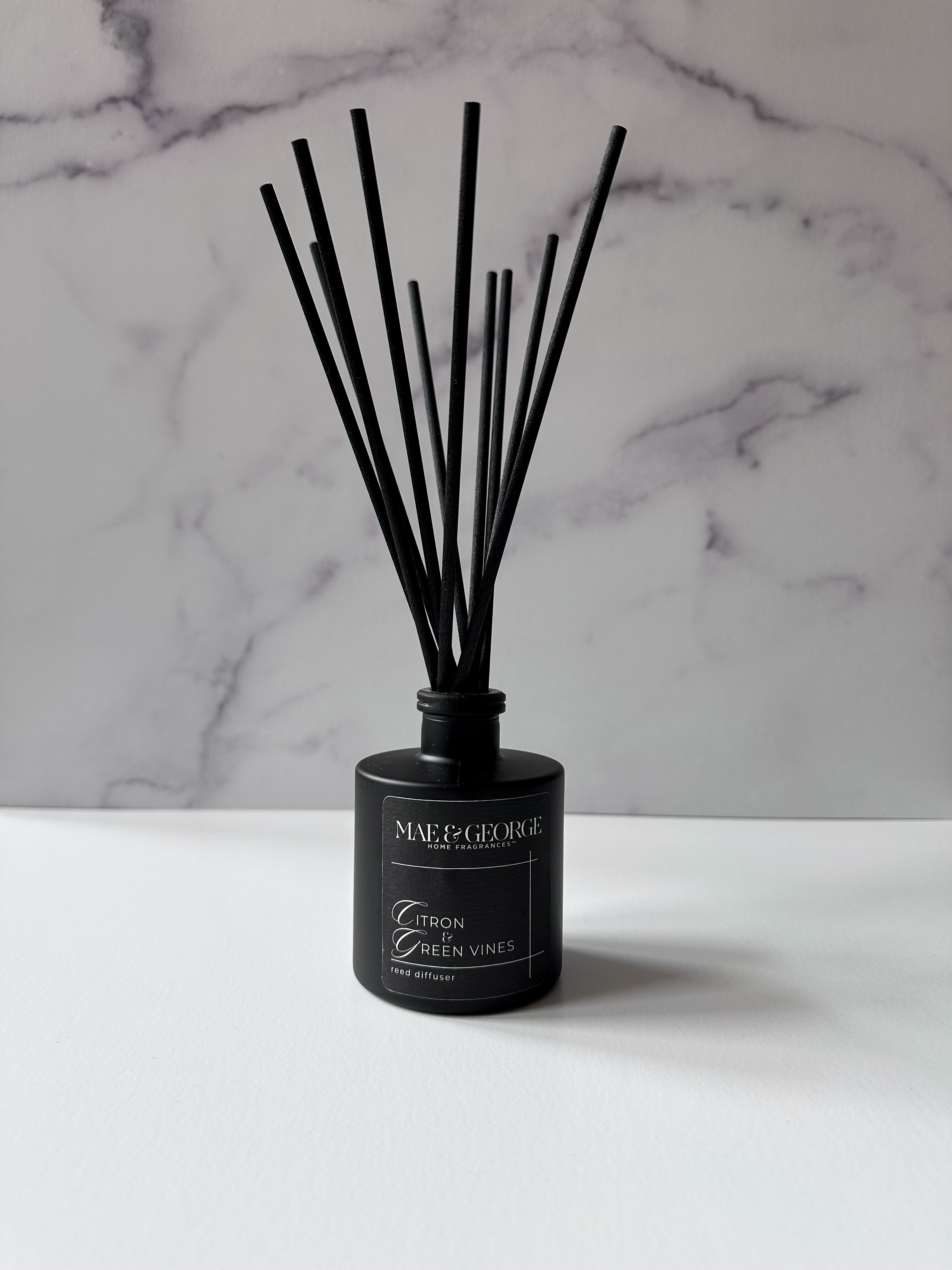 Reed diffuser with natural reeds on a styled surface — care and placement tips by Mae & George Home Fragrances