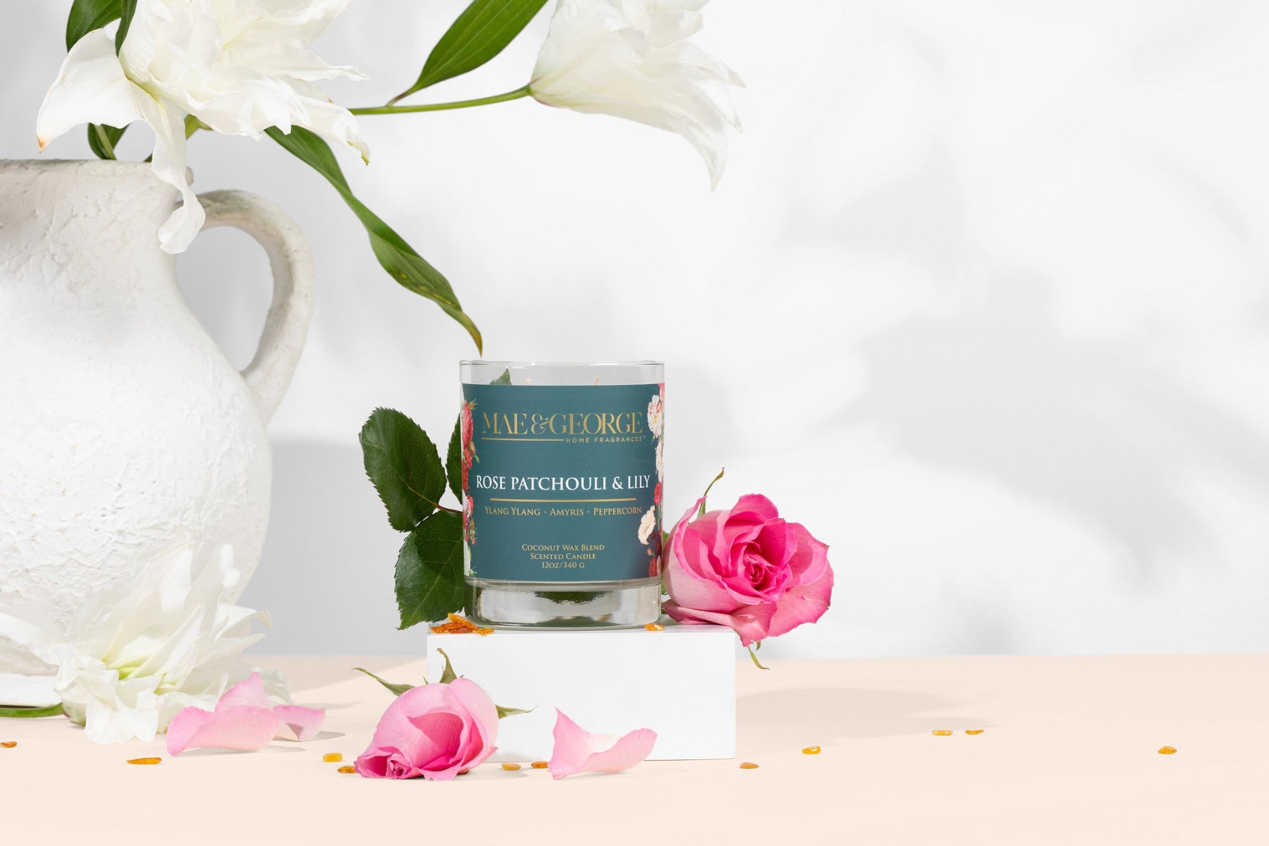 Rose Patchouli & Lily Candle on background with roses around